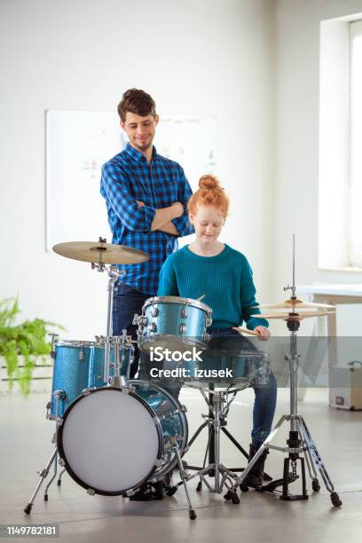 Teacher Looking At Drummer Practicing In Classroom Stock Photo - Download Image Now - 12-13 Years, 30-34 Years, Adult