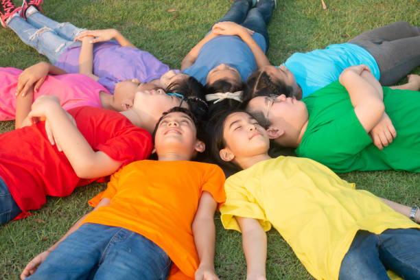 istock Group of student's friendship and team work lay down on the grass relaxing 1149784127