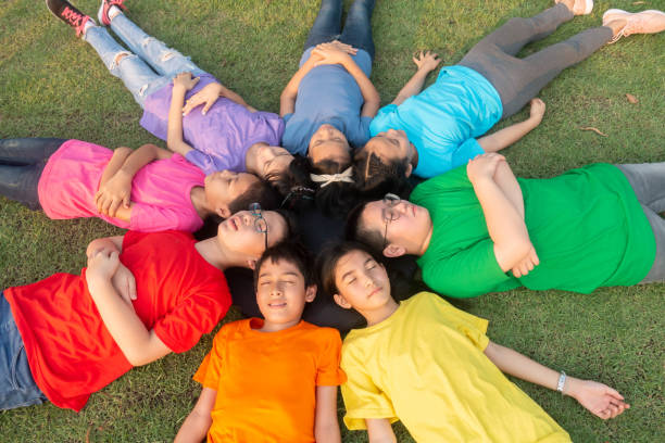 istock Group of student's friendship and team work lay down on the grass relaxing 1149784149