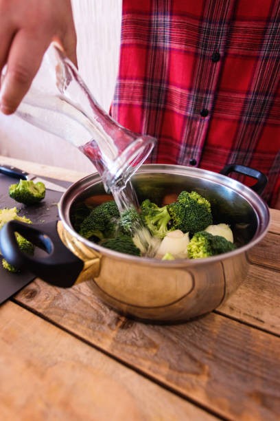 istock Broccoli cream soup preparing, pouring water into pot 1149795724