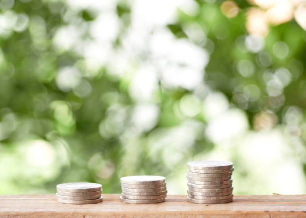 istock coins on table outdoors with nature green bokeh background 1149798704