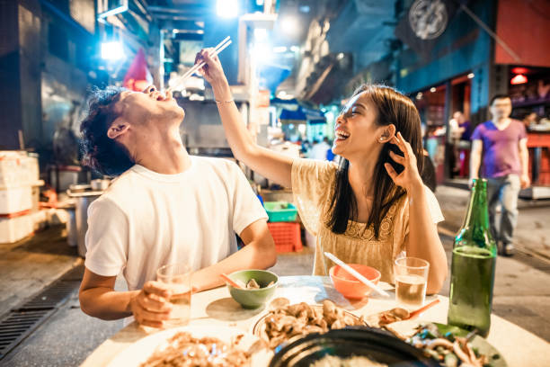 Asian couple enjoying street food in Hong Kong stock photo