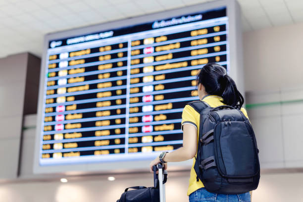 istock Woman with backpack looking flight timetable board, check flight at the international airport to travel on weekend. 1149808942