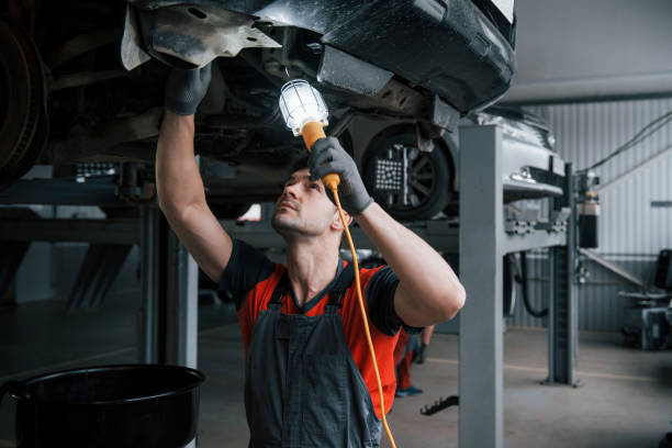 istock By using lighting instrument. Man at the workshop in uniform fixes broken parts of the modern car 1149814570