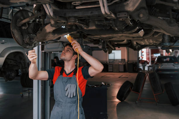 istock Ready for replacement. Man at the workshop in uniform fixes broken parts of the modern car 1149814587