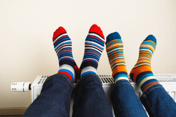 istock legs with colorful socks on heating radiator 1149820343