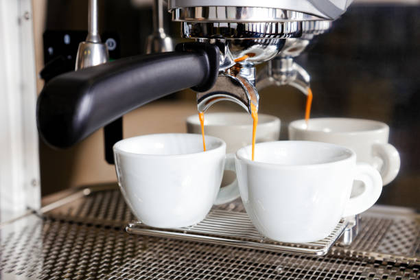 istock Coffee brewing in coffee machine. Espresso pouring in two cups. 1149820560