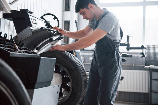 istock Technologies make it easier. Young man works with wheel's disks at the workshop at daytime 1149820569