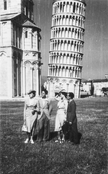 Elegant dressed couples having fun visiting Pisa in the 1936.Italy. Elegant dressed couples having fun visiting the famous Pisa tower in the 1936.Italy. 1930s style men image created 1920s old fashioned stock pictures, royalty-free photos & images