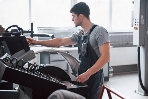 istock Programming the device. Young man works with wheel's disks at the workshop at daytime 1149820856