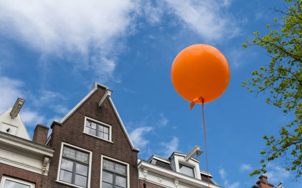 Orange balloon against blue sky in Amsterdam, Netherlands