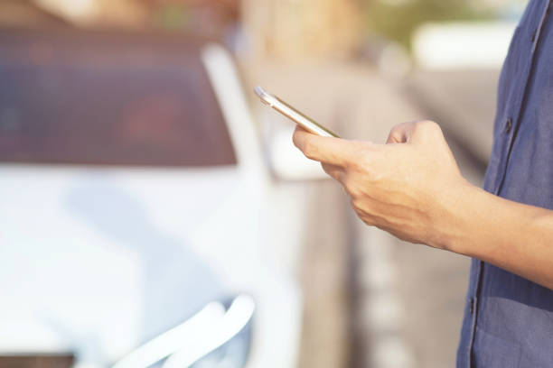 istock close up hand people man stand using the mobile smart phone in the roadside wayside. call a car mechanic ask for help assistance because car broken. 1149823183