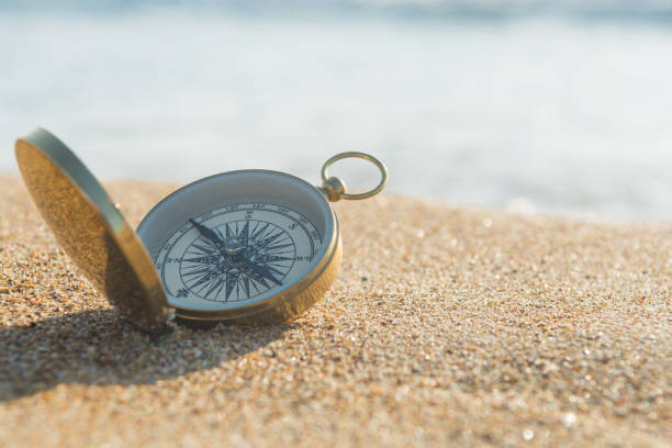 compass on the golden sand by the sea - compass symbol direction guide imagens e fotografias de stock