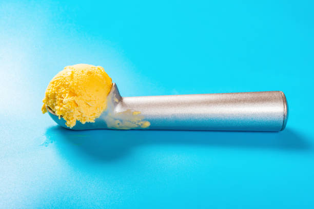 istock side view spoon with mango flavor ice cream ball on blue background 1149825705