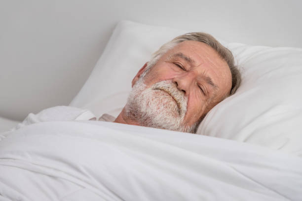 istock Senior elderly man sleeping with white blanket in bedroom 1149827002