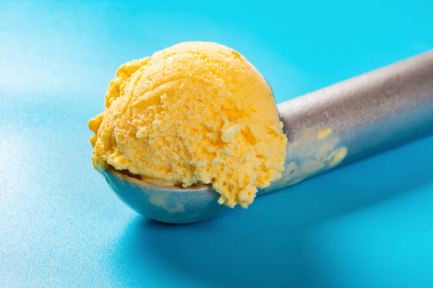 istock spoon with mango flavor ice cream ball on blue background close up 1149827960