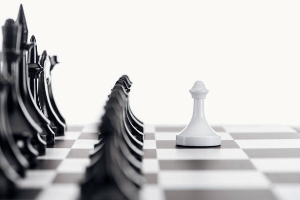 istock selective focus of chessboard with black chess figures and white pawn in front isolated on white 1149832646