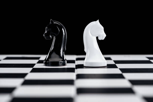 istock selective focus of chessboard and white and black knights isolated on black 1149832695