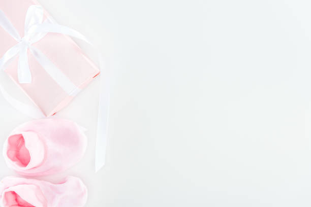istock top view of pink booties and gift box on white background with copy space 1149834958