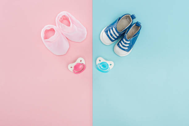 istock top view of pacifiers, booties, sneakers on pink and blue background with copy space 1149835042