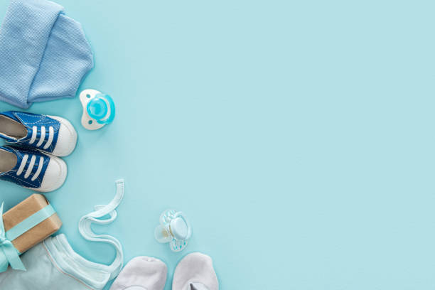 istock top view of pacifiers, gift, sneakers, bonnet, booties, hat on blue background with copy space 1149835071