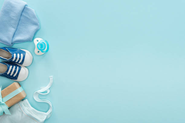 istock top view of pacifier, gift, sneakers, bonnet, hat on blue background with copy space 1149835077