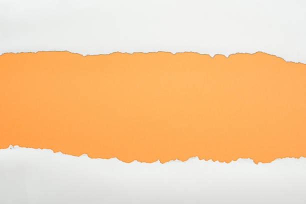 istock ragged white textured paper with copy space on orange background 1149835609