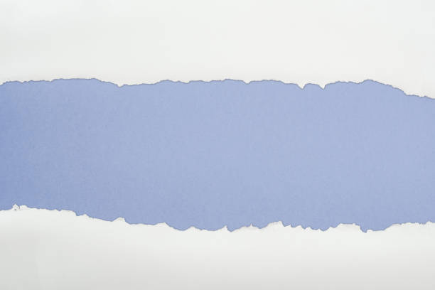 istock tattered white textured paper with copy space on blue background 1149835800