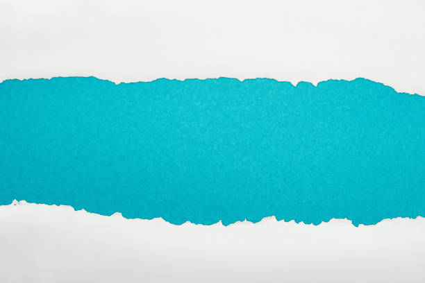 istock ragged white paper with copy space on blue background 1149835807
