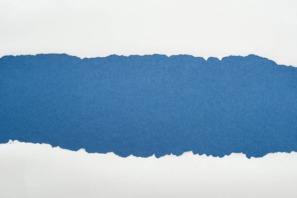 istock ragged white textured paper with copy space on deep blue background 1149835818
