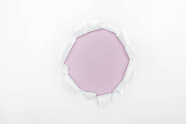 istock ragged hole in textured white paper on light purple background 1149836647