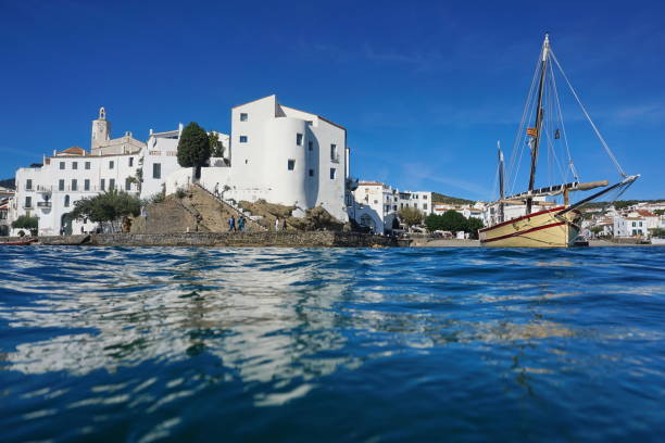 Coastal village of Cadaques with a traditional boat, seen from water surface, Mediterranean sea, Costa Brava, Catalonia, Spain