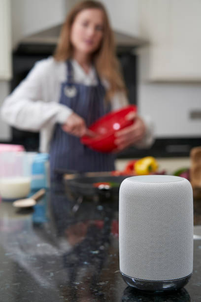 istock Woman Preparing Meal At Home Asking Digital Assistant Question 1149851377