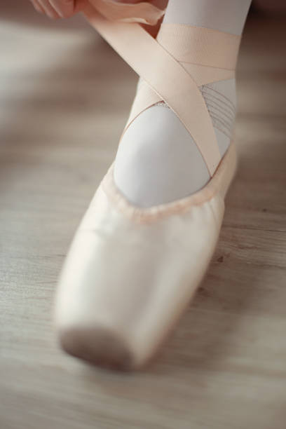 istock Ballerina puts on pointe ballet shoes 1149856099
