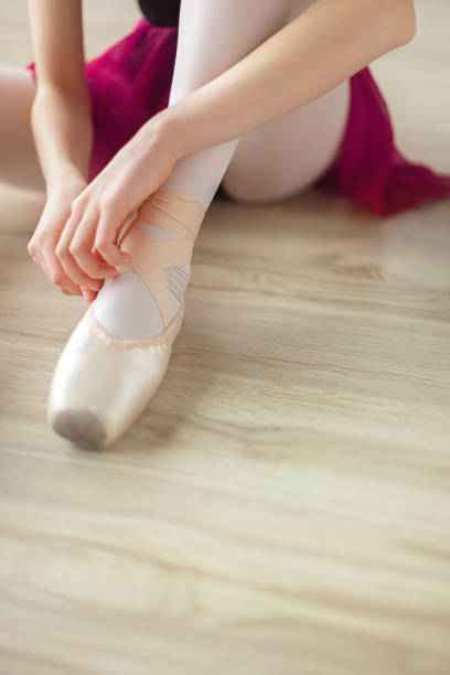 istock Ballerina puts on pointe ballet shoes 1149856996