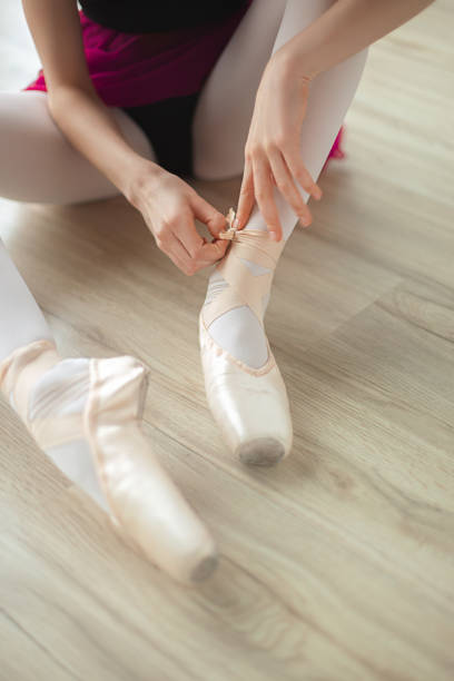 istock Ballerina puts on pointe ballet shoes 1149857062