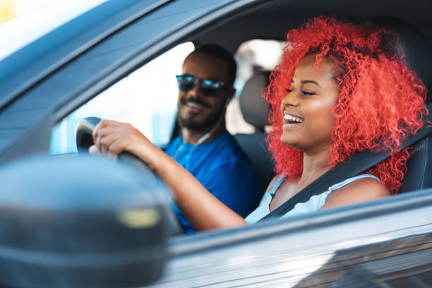 coppia afro in viaggio in auto - car insurance women driving foto e immagini stock