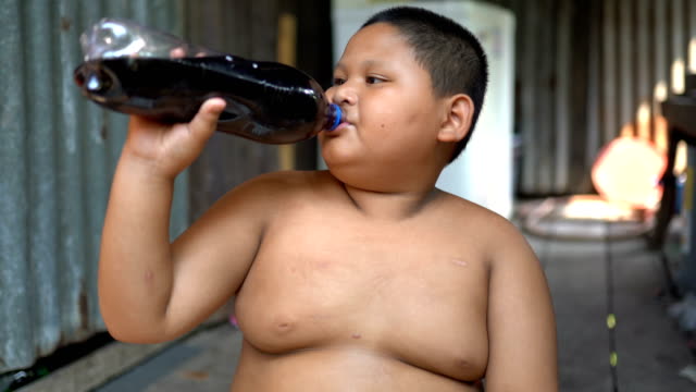 Asian boy is drinking a cola