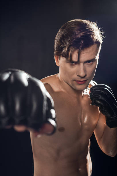 istock Selective focus of concentrated boxer in boxing gloves training and looking at camera 1149876734