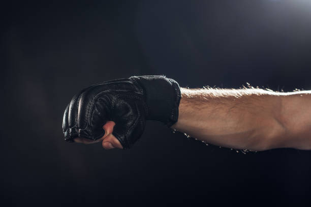 istock Cropped view of boxer in leather glove on black 1149876741