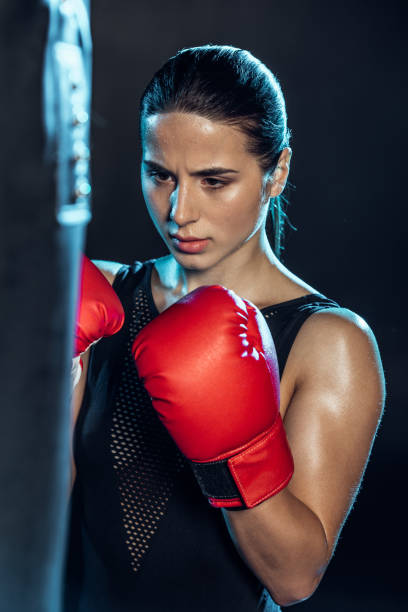 istock exhausted boxer in red gloves looking at punching bag on black 1149876796