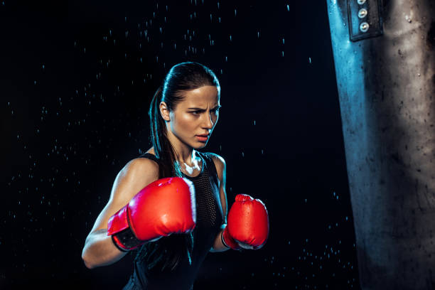 istock Pensive boxer in red boxing gloves training under water drops on black 1149876834