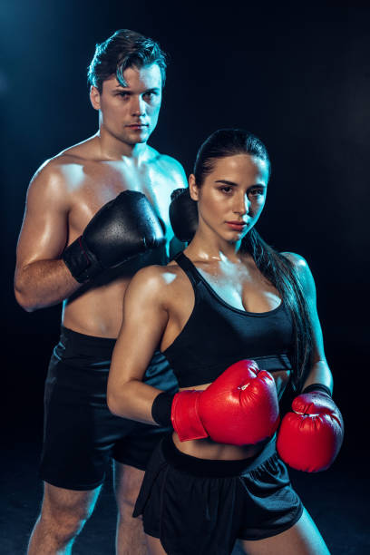 istock Two boxers in boxing gloves looking at camera on black 1149876924