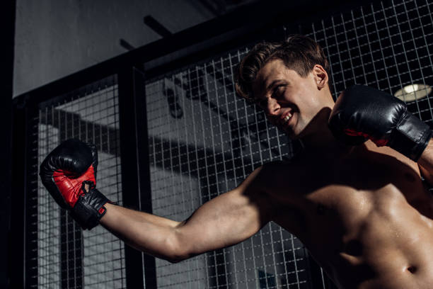 istock Handsome boxer in black boxing gloves training with smile 1149877043