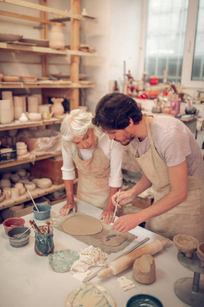 istock Nice pleasant people painting on clay pieces 1149878986