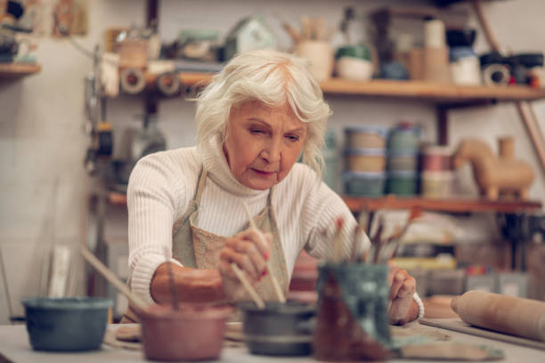 istock Nice aged woman putting a brush into paint 1149878997