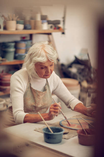 istock Pleasant grey haired woman working alone in the workshop 1149879004