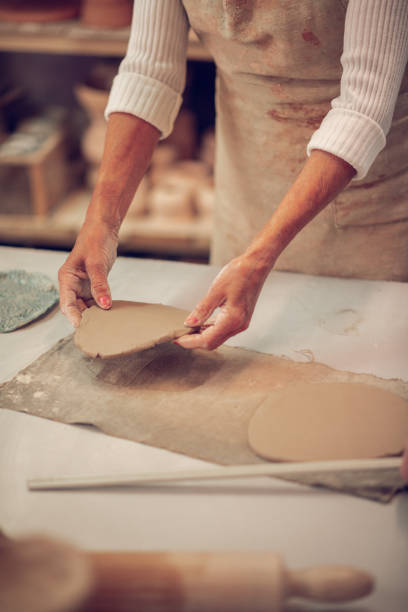 istock Close up of female hands with a clay piece in them 1149879101
