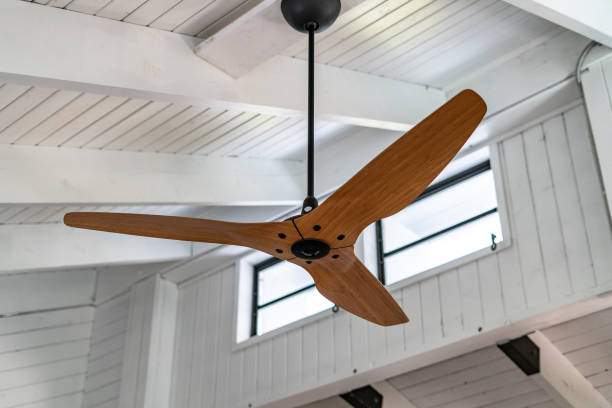 Tropical Florida Keys house interior fan and celing Traditionally built Florida Keys with white wooden walls and ceiling  with upper crank out vent windows with bamboo finish large ceiling fan. Could be used for multiple purposed including interior design, tropical style, beamed ceiling, and clerestory windows. ceiling fan stock pictures, royalty-free photos & images