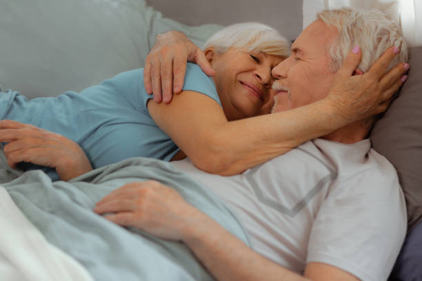 istock Loving wife tenderly hugging her spouse while lying with him 1149885106